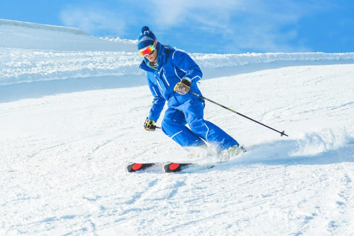 a man riding skis down a snow covered slope